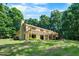Rear exterior featuring a spacious wooden deck, chimney and lush backyard at 5822 Country Lane Dr, Durham, NC 27705