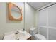 Cozy bathroom with a round framed mirror, a white toilet, and ample lighting at 5822 Country Lane Dr, Durham, NC 27705