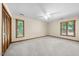 Spacious bedroom with carpet floors, two windows, ceiling fan and a closet with louvered doors at 5822 Country Lane Dr, Durham, NC 27705