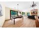 Open dining room featuring wood floors, modern chandelier, access to the living room and deck at 5822 Country Lane Dr, Durham, NC 27705