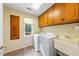 Bright laundry room featuring a sink, full-size washer and dryer, cabinets, and a window at 5822 Country Lane Dr, Durham, NC 27705