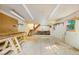 Large workshop area with worktables, pegboard walls, bright lighting, and convenient access to the stairwell at 5822 Country Lane Dr, Durham, NC 27705