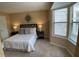 Comfortable bedroom with a queen size bed, neutral decor, bay window, and warm lighting at 600 Audobon Lake Dr # One B21, Durham, NC 27713