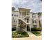 Apartment building exterior showcases multiple levels with exterior stairs, a green lawn, and neatly trimmed shrubs at 600 Audobon Lake Dr # One B21, Durham, NC 27713