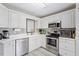 Well-equipped kitchen with stainless steel appliances, white cabinets, and ample counter space at 6032 Epping Forest Dr, Raleigh, NC 27613