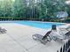 Community pool with lounge chairs, surrounded by lush greenery for a relaxing atmosphere at 6032 Epping Forest Dr, Raleigh, NC 27613