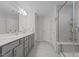 Modern bathroom with dual sink vanity, glass shower enclosure, and neutral gray tiling at 604 Craftsman Ridge Trail Trl, Knightdale, NC 27545