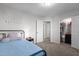 Neat bedroom featuring neutral carpet, a bed, bedside table, and door to closet and hallway at 604 Craftsman Ridge Trail Trl, Knightdale, NC 27545