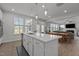 Modern kitchen with white cabinets, stainless steel appliances, and an island with bar seating at 604 Craftsman Ridge Trail Trl, Knightdale, NC 27545