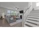 Bright living room with gray sofa, fireplace, and large windows overlooking the yard at 604 Craftsman Ridge Trail Trl, Knightdale, NC 27545