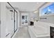 Contemporary bathroom showcasing a luxurious soaking tub, glass shower, and view into the bedroom at 6404 Fauvette Lane Ln, Holly Springs, NC 27540