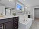 Modern bathroom featuring a soaking tub, a glass-enclosed shower, and dual sinks with gold hardware at 6404 Fauvette Lane Ln, Holly Springs, NC 27540