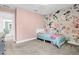 Bright bedroom featuring floral wallpaper accent, carpet flooring, and a twin bed, creating a cozy space at 6404 Fauvette Lane Ln, Holly Springs, NC 27540