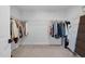 Spacious walk-in closet with ample hanging space, shelving, and carpeted floors providing organized storage at 6404 Fauvette Lane Ln, Holly Springs, NC 27540