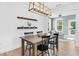 Dining room featuring a wood table, stylish light fixture and view to sunroom, blending for gatherings at 6404 Fauvette Lane Ln, Holly Springs, NC 27540
