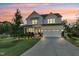 The front exterior of the home at dusk, enhanced by landscape lighting and a manicured lawn at 6404 Fauvette Lane Ln, Holly Springs, NC 27540