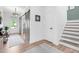 Hallway with wood floors, a barn door, access to foyer and staircase, creating a flow between spaces at 6404 Fauvette Lane Ln, Holly Springs, NC 27540