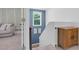 Hallway with white and blue walls, carpeted stairs, and a decorative wooden cabinet at 6404 Fauvette Lane Ln, Holly Springs, NC 27540