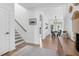 Hallway featuring wood floors, staircase and view of dining area, blending functionality with modern design elements at 6404 Fauvette Lane Ln, Holly Springs, NC 27540