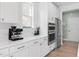 Modern kitchen featuring stainless steel appliances, quartz countertops and stylish white cabinetry at 6404 Fauvette Lane Ln, Holly Springs, NC 27540