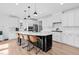 Spacious kitchen with white cabinets, a dark island, pendant lighting, and seating for four at 6404 Fauvette Lane Ln, Holly Springs, NC 27540