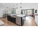 Bright, open living area with a modern kitchen island that overlooks the dining area and living room at 6404 Fauvette Lane Ln, Holly Springs, NC 27540