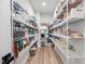 Spacious walk-in pantry with floor-to-ceiling shelving and hardwood floors, perfect for organized storage at 6404 Fauvette Lane Ln, Holly Springs, NC 27540