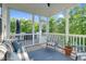Inviting screened porch featuring outdoor seating, wood decking, and views of the lush backyard at 6404 Fauvette Lane Ln, Holly Springs, NC 27540