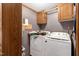 Laundry room with a washer, dryer, cabinets, and striped wallpaper at 70 Fieldside Dr, Louisburg, NC 27549