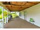 Covered porch featuring painted wood posts, a concrete floor, and a white door at 70 Fieldside Dr, Louisburg, NC 27549