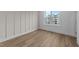 Empty bedroom with wood floors, window, and white board and batten accent wall at 710 W North St # 102, Raleigh, NC 27603