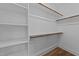 Walk-in closet with wood closet rods and built in shelving for optimal storage solutions at 710 W North St # 102, Raleigh, NC 27603