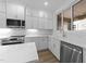 Close-up of kitchen showcasing white cabinets, stainless steel appliances, and marble countertops at 710 W North St # 102, Raleigh, NC 27603