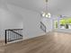Open-concept living room with modern light fixture, wood floors, and staircase at 710 W North St # 102, Raleigh, NC 27603
