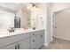 Bathroom boasts a double sink vanity, sleek gray cabinets, and a well-lit mirror, plus a connecting doorway at 72 Ina Rose Ln, Four Oaks, NC 27524