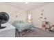 Bedroom with wall decor, bookshelves, and a soft green bedspread, offering a relaxing and organized space at 72 Ina Rose Ln, Four Oaks, NC 27524
