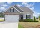 Charming one-story home featuring stone accents, attached garage, and a well-maintained lawn with flower beds at 72 Ina Rose Ln, Four Oaks, NC 27524