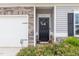 Close up of front door featuring a decorative wreath and lovely landscaping with flower bushes at 72 Ina Rose Ln, Four Oaks, NC 27524