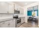 Modern kitchen with stainless steel appliances, granite countertops, and white cabinetry at 72 Ina Rose Ln, Four Oaks, NC 27524