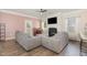 Cozy living room featuring a fireplace, piano and a large, comfortable gray sofa at 72 Ina Rose Ln, Four Oaks, NC 27524