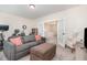 Cozy living room with a comfortable gray sofa, plush ottoman, and an adjacent bonus room via french doors at 72 Ina Rose Ln, Four Oaks, NC 27524