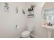 Stylish powder room featuring modern decor, floating shelves and a pedestal sink at 72 Ina Rose Ln, Four Oaks, NC 27524