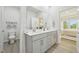 Modern bathroom featuring double sinks, white countertops, and a view into the main bedroom at 740 Deschutes Dr, Garner, NC 27529