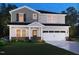 Charming two-story home with gray siding, brick accents, landscaped flower beds, and a welcoming front porch at 740 Deschutes Dr, Garner, NC 27529