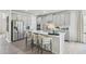Bright kitchen with stainless steel appliances, light gray cabinets, a large island, and stylish barstools at 740 Deschutes Dr, Garner, NC 27529