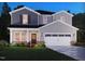 Charming two-story home with gray siding, a two-car garage, and a well-maintained lawn and flowerbed at 744 Deschutes Dr, Garner, NC 27529