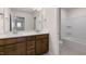 Bathroom featuring dual vanities with white countertops, wood cabinets, and a shower and tub combination at 79 Bronco Pace Dr, Clayton, NC 27520