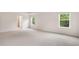 A large primary bedroom has two windows with neutral carpeting and a door to the Primary bath at 79 Bronco Pace Dr, Clayton, NC 27520