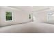 Primary bedroom featuring neutral carpeting, paint, tray ceiling, and three bright windows at 79 Bronco Pace Dr, Clayton, NC 27520