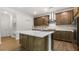 Stylish kitchen island with stainless steel sink and stainless hood range and modern lighting at 79 Bronco Pace Dr, Clayton, NC 27520